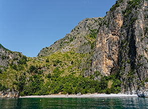 La Spiaggia della Risima dominata da un’alta parete di roccia.