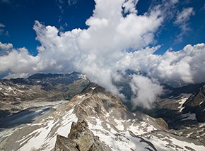 Panorama verso Nord dalla cima della Lobbia Alta , i monti della Presanella sono nascosti dalle nuvole ma al centro si distinguono le cime della Lobbia di Mezzo e della Lobbia Bassa.