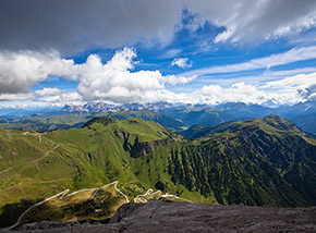Panorama dolomitico: sotto di noi la strada che collega Malga Ciapela con Passo Fedaia, oltre il Padon, le Crepe Rosse e il Sass de Roi, menre all’orizzonte le Dolomiti nord-orientali (le Tofane etc.)