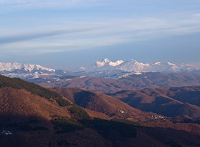 Lunghe ombre si allungano sul paesaggio mentre gli ultimi tenui raggi di Sole illuminano ancora all’orizzonte le bianche cime della Laga e Gran Sasso.