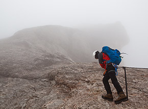 Sopra di noi la cresta della montagna sembra protrarsi nel vuoto (Via ferrata della Marmolada).