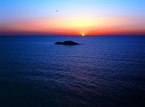 Il Sole tramonta dietro lo Scoglio del Medico, sulla costa occidentale di Ustica.
