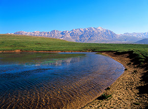 Sulle sponde del Lago di Racollo, dove si specchiano le cime della Catena Orientale del Gran Sasso.