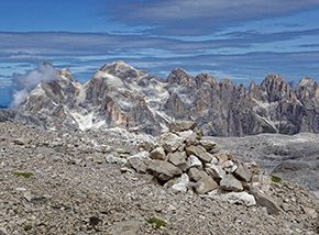 Ometto sulla cresta sommitale de la Fradusta, sullo sfondo si ergono: Cimon della Pala (seminascosto dalle nubi a sx), Cima della Vezzana, Cima dei Bureloni, Cima di Val Grande e Cima del Focobon.