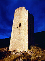 L’ultimo raggio di Sole accende la torre medioevale di Poggio Poponesco sotto un cielo temporalesco.