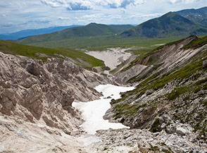 Ultimi nevai alle pendici del Canalone Sud-Ovest di Santa Colomba in vista de la Faeta.