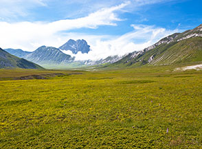 Dai prati di Campo Imperatore la vista si allunga fino al Corno Grande incorniciato fra le nuvole.