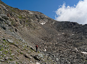 Inoltrandosi verso il vasto catino di ghiaie sul Versante Sud del Mont Glacier, dove passa la Via Normale per la cima.