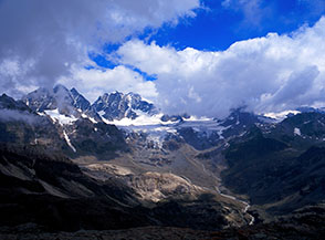 Nuvoloni si addensano sul Bernina, traspare la Vedretta di Scerscen Superiore e le cime pi&ugrave; alte del gruppo: (da sx) il Pizzo Roseg, il Monte di Scerscen ed il Pizzo Bernina.