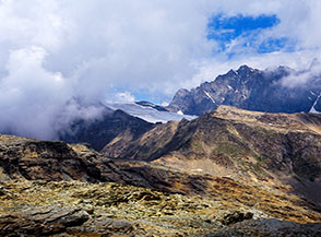 Oltre la Cresta Nord-Ovest del Sasso Nero, intravediamo la Vedretta di Scerscen Inferiore, preceduta dalla sagoma scura dell&rsquo;Albergo di Scerscen (in abbandono).