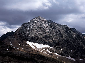 Un raggio di sole illumina la scura Parete Nord-Ovest del Pizzo Painale.