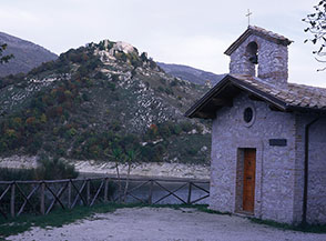 Una cappellina che si trova  ai bordi del Lago del Turano, nei pressi di Castel di Tora, alle spalle la Rocca di Antuni.
