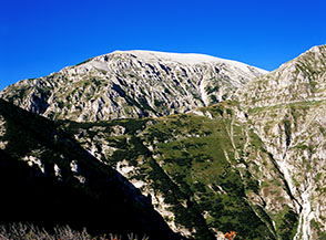 Il Valico de la Carozza illuminato dal Sole, alle sue spalle il Monte Acquaviva.