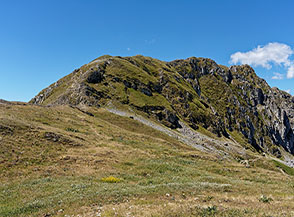 I prati alla Sella di Celano oltre cui si sviluppa la Cresta Est del Monte Tino.