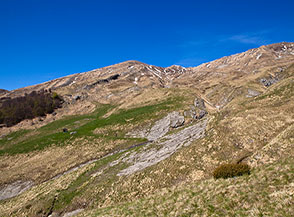 Vista sulla terrazza prativa ai piedi dell&rsquo;anfiteatro vallivo delle Cento Fonti, sullo sfondo al centro l&rsquo;Anticima Sud della Laghetta.