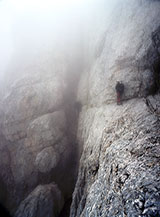 Fra le nuvole nel delicato passaggio su parete all&rsquo;attraversamento del secondo canale della Via Ferrata dei Ginepri ex Brizio.