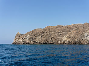 Vista su Al Jazirah, sulla cima si scorge il piccolo faro bianco dell&rsquo;isola mentre sulla sx delle antiche fortificazioni poste a protezione del vicino Palazzo del sultano.