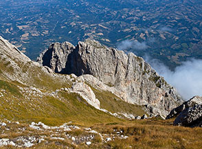 Affaccio sui ripidi canali prativi che dalla Cresta Est del Monte Camicia calano sul versante teramano, al centro si distingue il roccioso Dente del Lupo.
