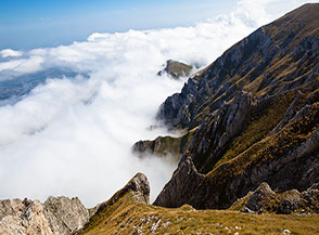I ripidi canali che segnano il versante settentrionale del Tremoggia affondano nella nebbia.
