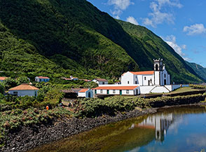 Tra le case della faj&atilde; rifulge la bianca chiesa del Santuario do Senhora da Caldeira de Santo Cristo.