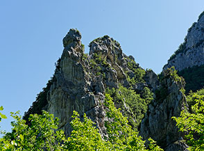 Suggestive formazioni rocciosi si ergono dai boschi della Val d&rsquo;Abisso.
