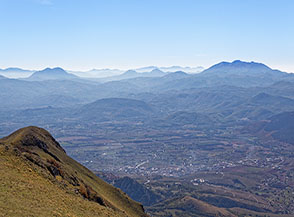 Vista verso sud dal Monte Volturino: sotto di noi la Val d&rsquo;Agri ed oltre, confusi tra la foschia, il Monte Alpi (sulla sx) ed il massiccio del Sirino.