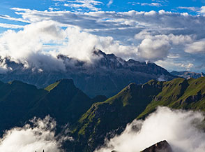 Lo sguardo si perde dolcemente all&rsquo;orizzonte riempiendo i vuoti lasciati dalle nuvole (panorama verso il Gruppo Sella dal Rifugio Capanna al Ghaicciaio).