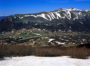 Vista su Passo San Leonardo dalla lingua di neve ai piedi della Rava della Giumenta Bianca.