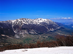 Vista sui Monti del Morrone dalla lingua di neve ai piedi della Rava della Giumenta Bianca.