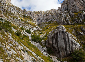 Superata la strozzatura con il salto di roccia il Canalino si riapre in un vasto e selvaggio canalone.