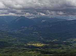 Sotto un cielo denso di grigie nubi a valle resiste un ultimo foro di luce (dalla cima del Capraro).
