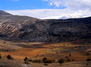 La bucolica conca di Piano del Monte alle pendici del Monte Stabiata, sullo sfondo la cresta innevata dello Ienca.
