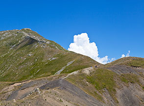 Il colletto di detriti grigi che s&rsquo;incontra al termine della Cresta Sud del Cimoncino (sullo sfondo).