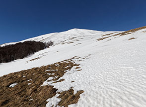 Usciti dal bosco ai piedi del vasto anfiteatro sul Versante Sud di Monte di Mezzo.