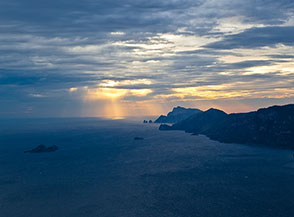 Frecce di luce colpiscono in lontananza il mare della Costiera Amalfitana.