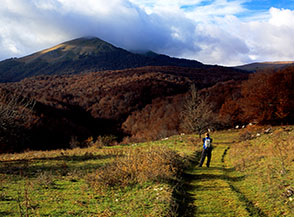 Lungo la pista che conduce nel Vallone Lampazzo, sullo sfondo incappucciato dalle nuvole la cresta di Rocca Genovese.