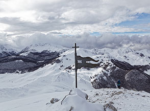 Dalla cima di Monte Godi lo sguardo si perde ad Ovest tra nuvole e cime imbiancate.