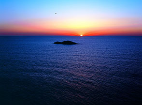 Il Sole tramonta dietro lo Scoglio del Medico, sulla costa occidentale di Ustica.