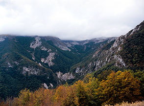 Vista sulla parte alta di Valle Scura sotto una coperta di nuvole che ne nasconde le cime.