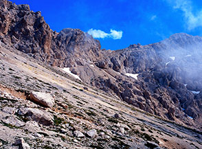 Dal vasto pendio di ghiaie nell&rsquo;Anfiteatro Nord dell&rsquo;Infornace vista sulla Cresta Est del monte.