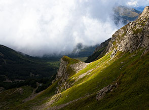 Una lama di luce accende i prati che degradano sull&rsquo;Anfiteatro di Pezzalunga.