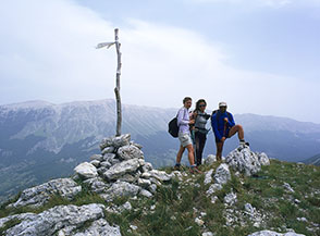 Sulla cima di Monte le Mucchia sferzati dal vento e con sfondo il Monte Amaro.