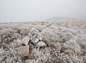 Fra l&rsquo;erba gelata un&rsquo;esile sentiero si spinge verso la cima del Rotella.