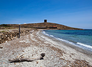 La spiaggia di Cala Trabuccato, e sullo sfondo la Punta e la Torre Trabuccato.