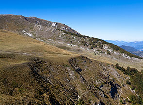 In secondo piano la cresta dei Coppi di San Franco bordata dal bosco.