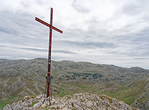Croce di vetta del Monte Etra con la dorsale del Sirente sullo sfondo.