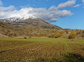 Dai coltivi di Vallelanci lo sguardo si alza sull&rsquo;inizio della catena del Sirente con il Monte Briccialone gi&agrave; imbiancato.