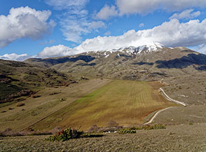 Affaccio sull&rsquo;ampia conca del Baullo nascosta tra le colline alle pendici del Monte Briccialone (sullo sfondo).