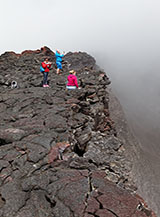 Turisti sul bordo del cratere sommitale del Piton de la Fournaise.
