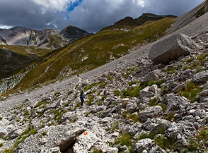 Attraversamento di un ghiaione lungo il sentiero che dalla Sella dei Grilli cala in Val Maone.